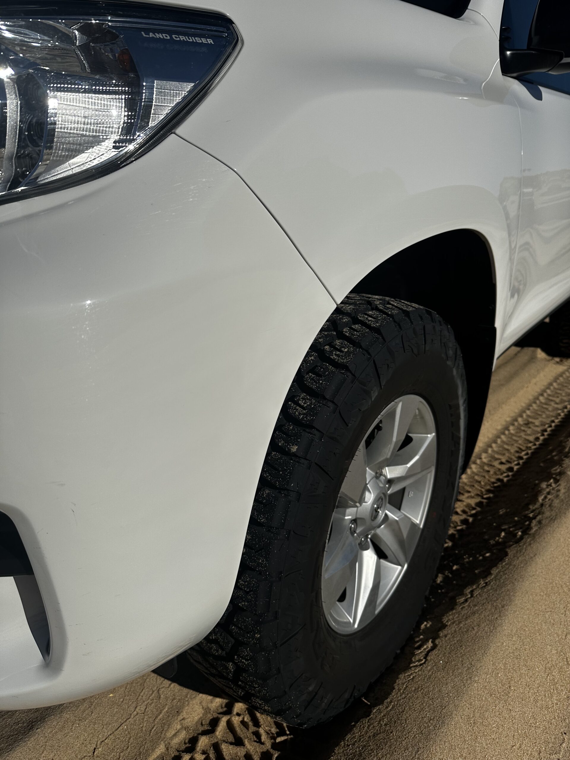 Vehicle and Camping Gear Maxxis Razr AT tyre fitted to a white Toyota Prado on sand