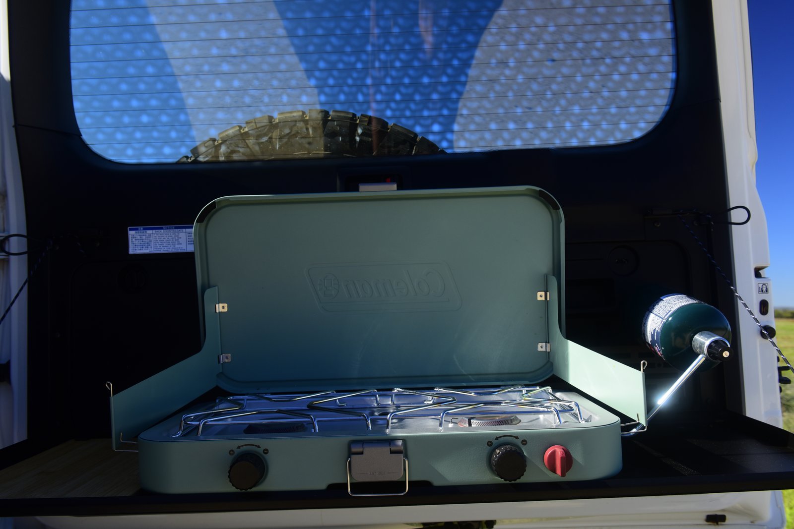 Vehicle and Camping Gear Coleman two-burner cooker set up on the tailgate of the Prado