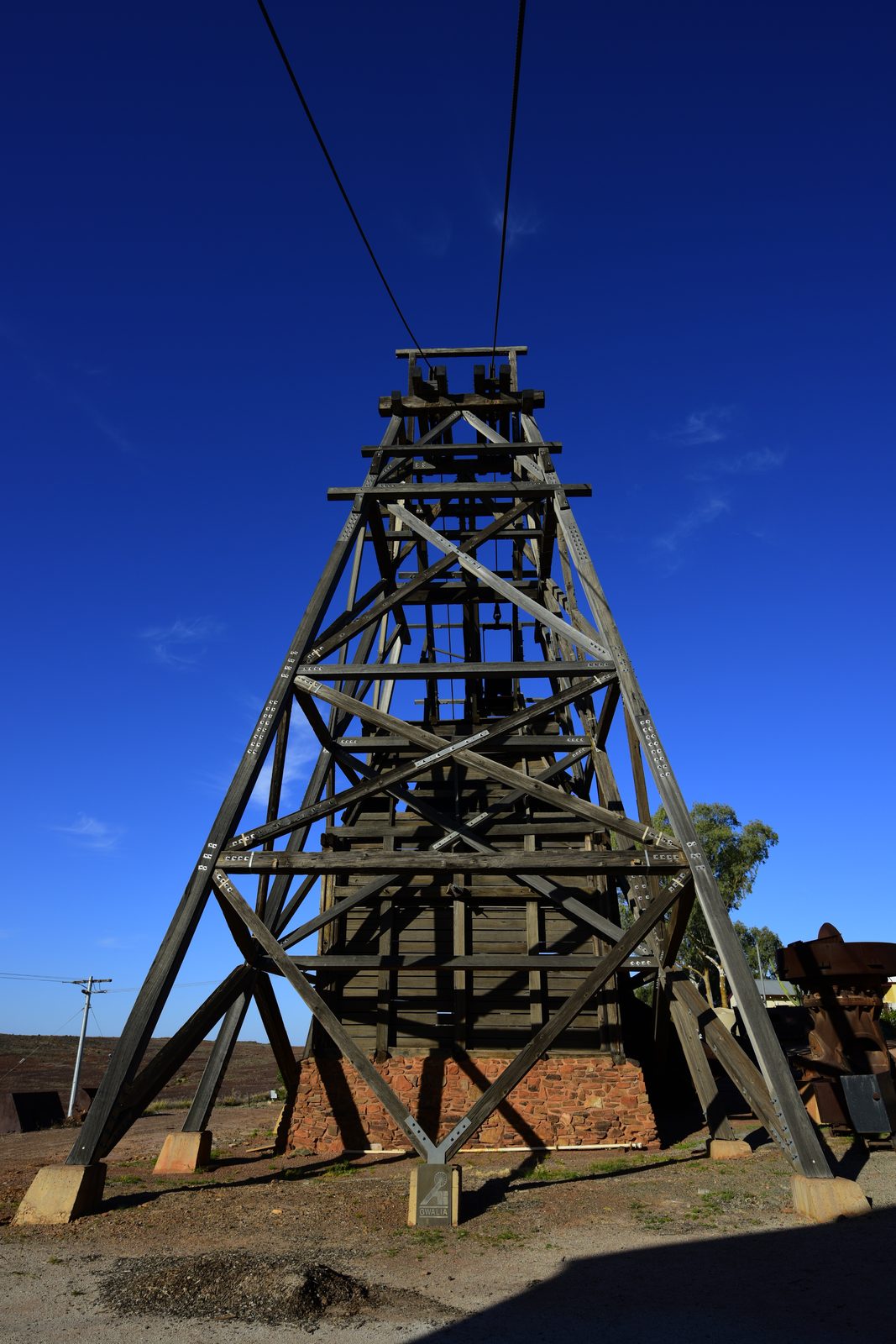 Kalgoorlie to Leonora: The Last Day of Never Having Swung a Detector Historic timber mine headframe at Gwalia against a clear blue sky